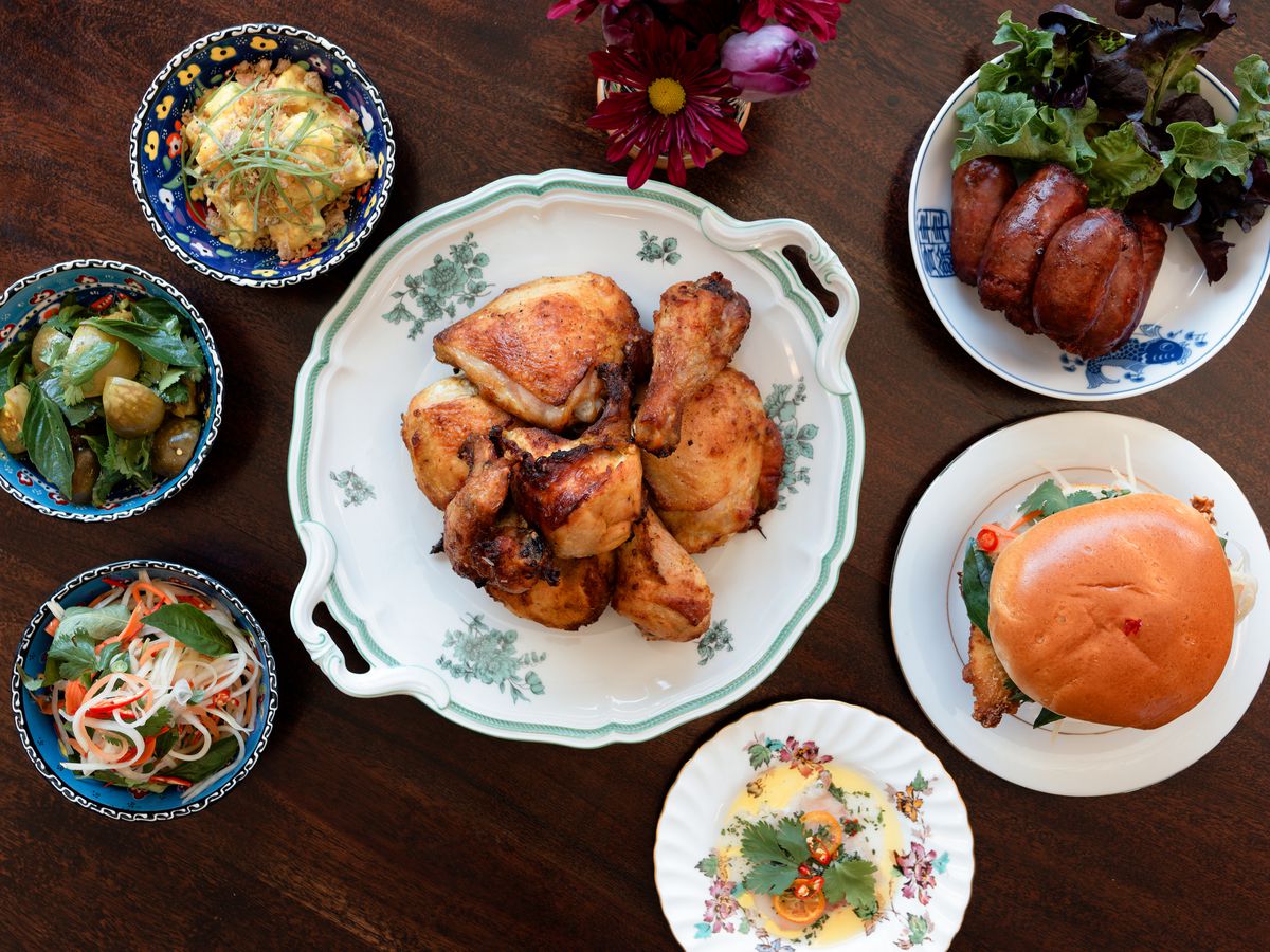A collection of seven dishes filled with food on a wooden table.