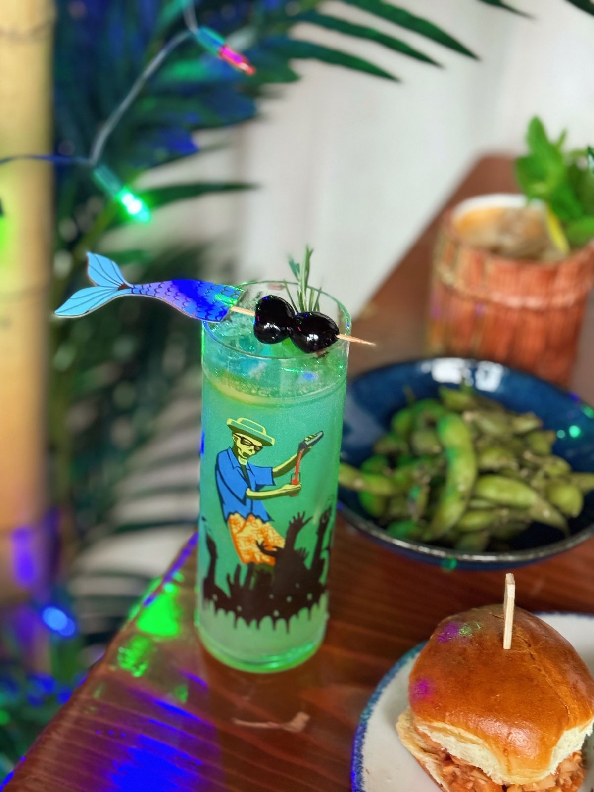 A blue tropical cocktail in a tiki glass. 