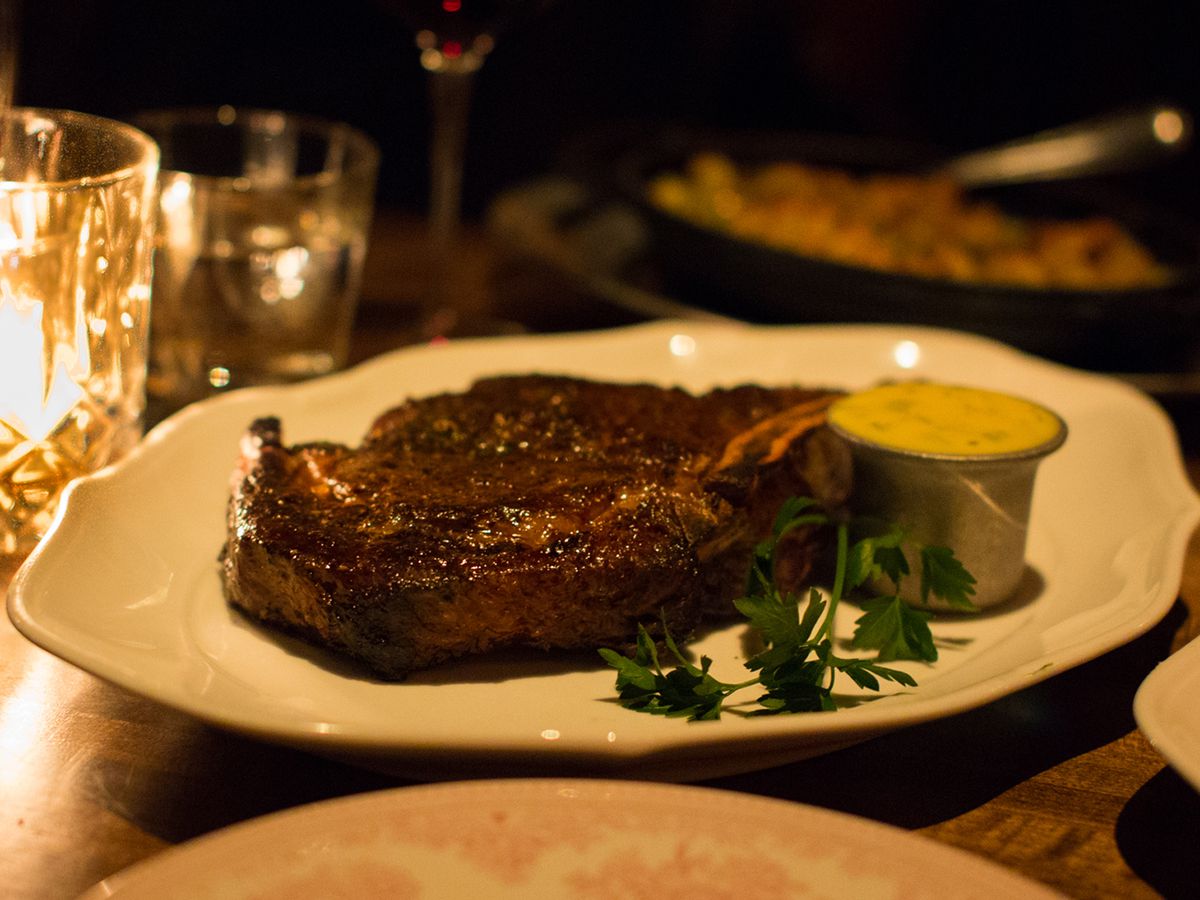 A bone-in rib eye with a cup of Béarnaise on the side.