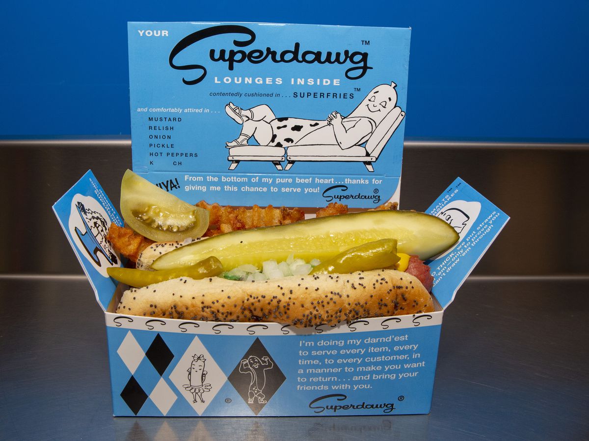 A blue cardboard rectangle food container with a hot dog inside.