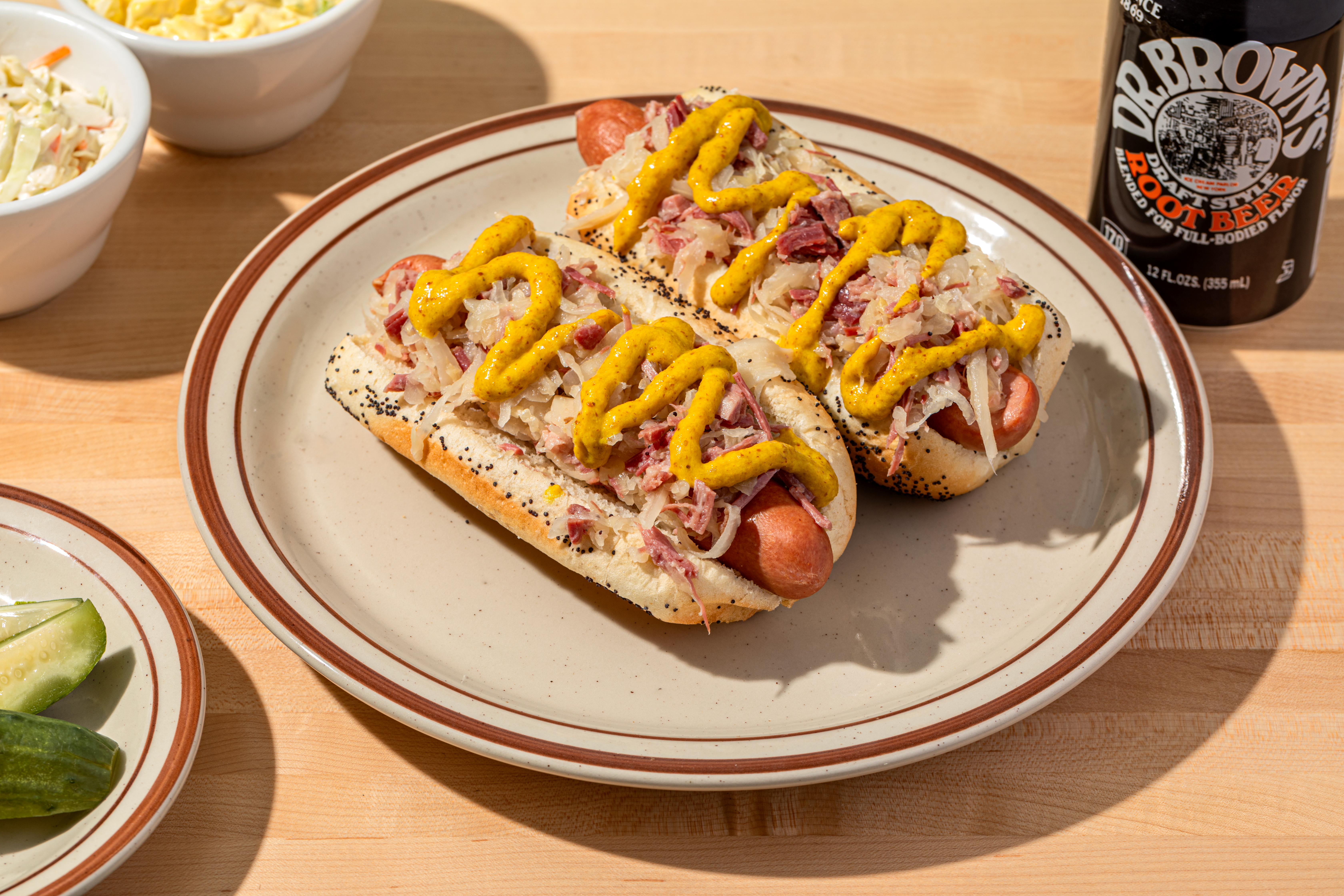 A plate holds two hot dogs smothered in corned beef hash and drizzled with brown mustard.