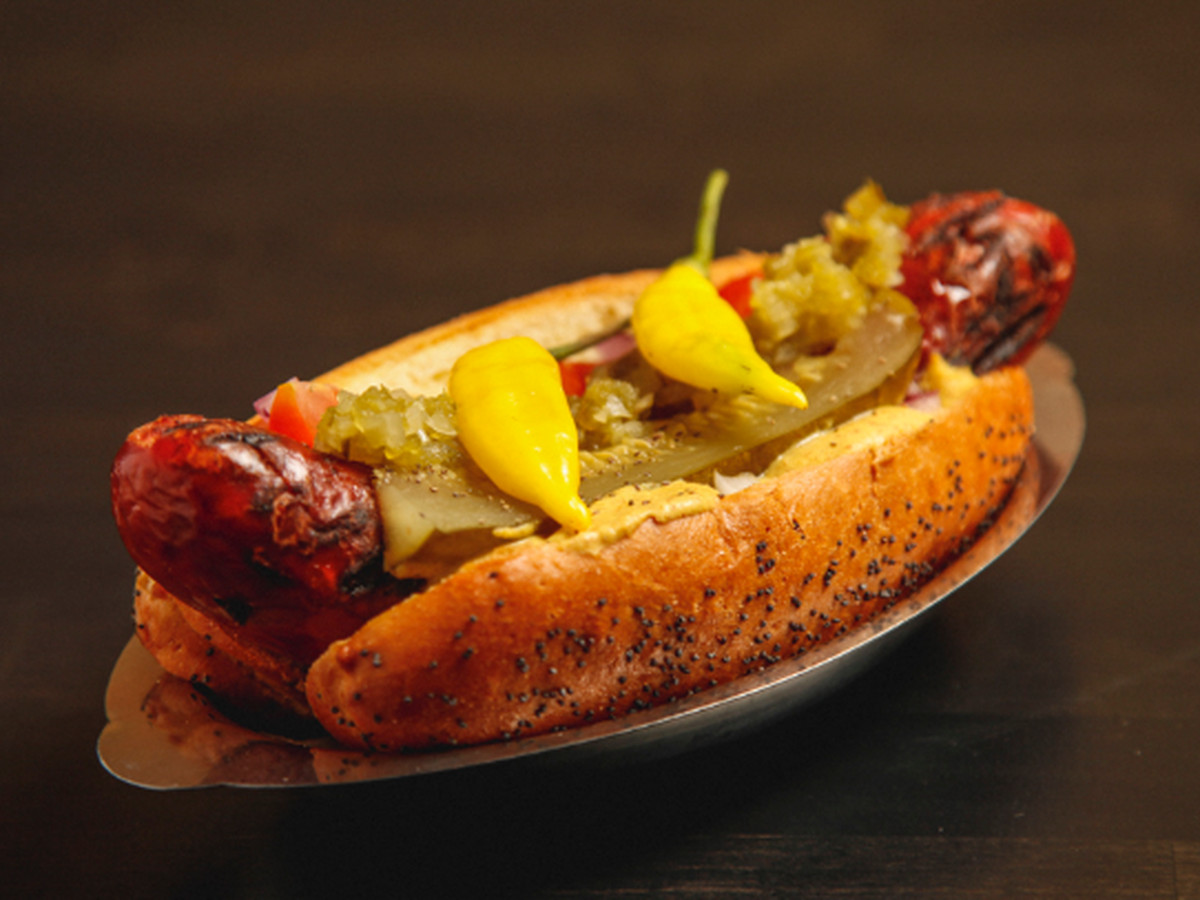 A duck fat hot dog garnished with Chicago-style toppings