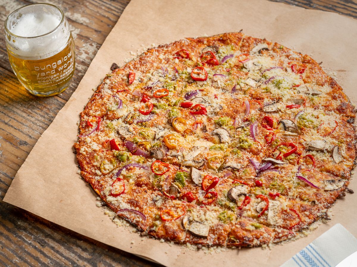 A pizza with a mug of beer.