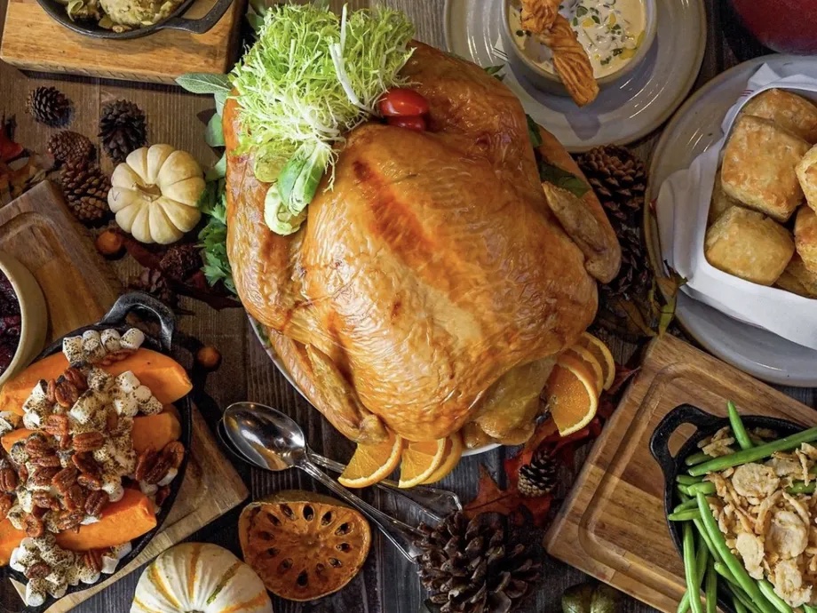A large roast turkey surrounded by smaller side dishes.
